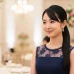 Kobieta w eleganckiej, nieduzej sukni w granatowym kolorze stojąca na weselu, tło dekoracje stołu weselnego